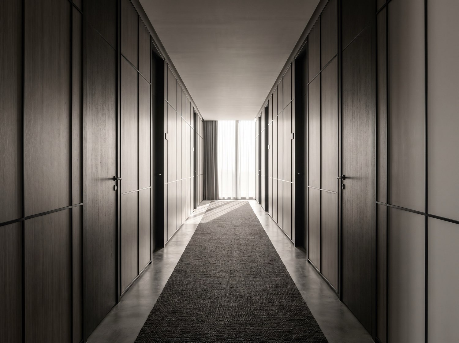 A hotel corridor with a strict grid of doors