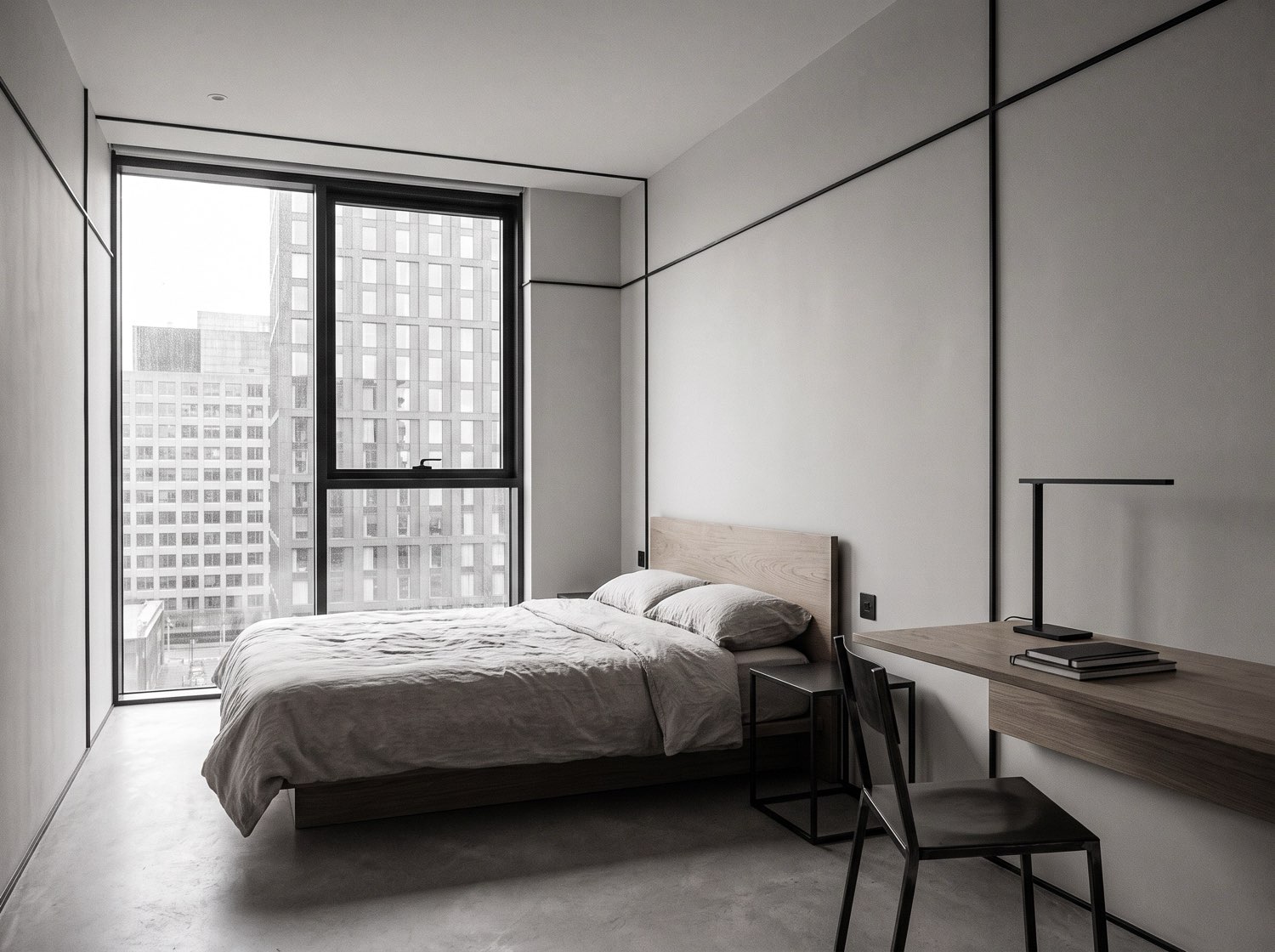 A modern hotel suite with floor-to-ceiling window onto the Manchester city grid